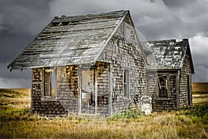 Small abandoned house with wringer washing machine outside.