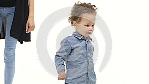 Small african american boy walks with his mother. White background. Slow motion