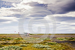 Small airfield in Iceland with small cessna plane with sheep on grasslands with nice sky