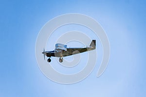 small airplane flying on blue sky with some clouds