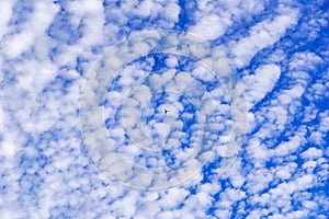 Small airplane flying on a cloudy sky background