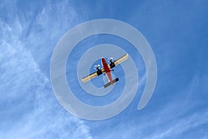 Small Airplane Flying at Low Altitude Under Blue Sky Viewed from Below