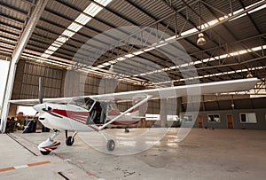 Small airplane with propeller in front parking in terminal.