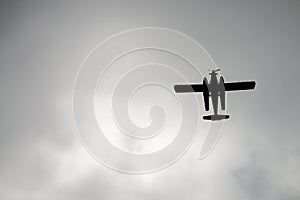 Small airplane silhouette against stormy sky