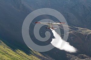 Small Airplane Spraying Mountain Lakes