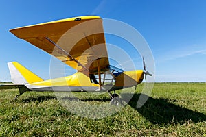 small airplane waiting on field, Yellow plane on the grass.