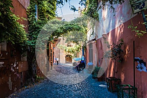 Small alley in the famous quarter trastevere in rom, italy. typical houses with colorful facades in a gasse with antique cobblesto