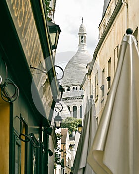 A small alley in Montmartre with the church of Sacre Coeur in ba
