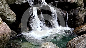 Small alpine waterfall with lake and turquoise water