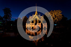 A small alter temple structure in a reflecting pool at night