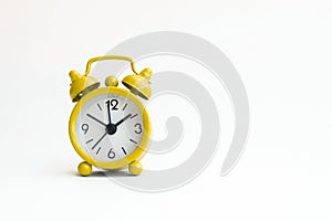 Small analogue yellow golden clock in isolated white background