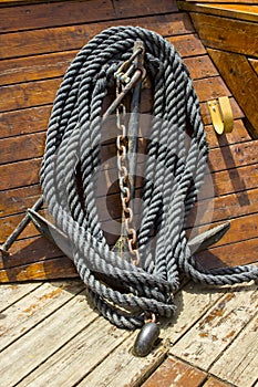 A small anchor, chain and rope stowed safely on a small boat photo