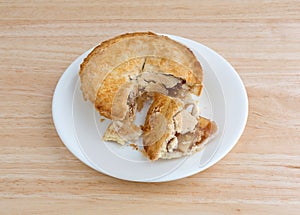 Small apple pie on plate upon a table top