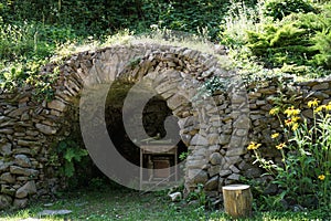 A small artificial cave built out flat stones layered carefully over each other.