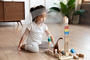 Small asian baby girl playing with cubes alone at home.