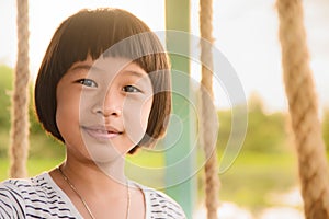 A small Asian girl is smiling happily.