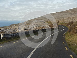 Small asphalt road in Burren National park, Mountains on the right, Atlantic ocean on the left, Part of Wild Atlantic Way