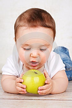 Small baby boy eating apple