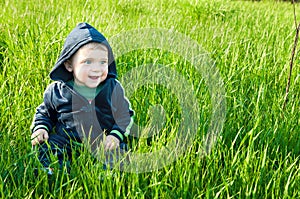 Small baby boy sitting in the grass