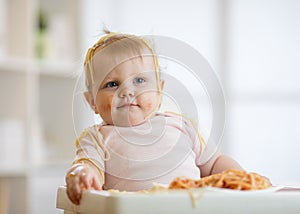 Small baby eating her lunch and making a mess