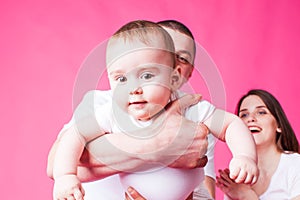 Small baby in father`s arms looking at the camera