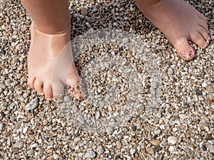 Baby feet close-up on the sand of the sea beach. Sea water washes the feet. Happy childhood. Rest at the sea. Summer