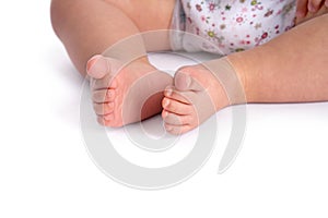 Small baby feet close up on white background