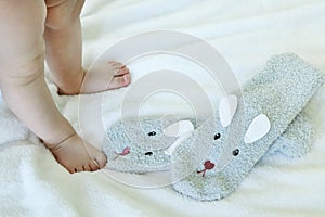 Small baby feet and knitted warm clothes for children in the form of socks. Children& x27;s fashion. Infant first steps. Copy