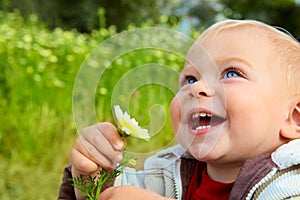 Small baby laughing with daisy photo