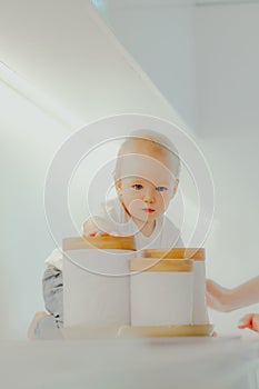 Small baby plays with spice jars while his mother looks after him