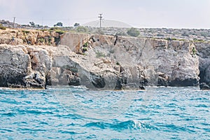 Small backwater surrounded by a stone cliff with azure water in Cyprus