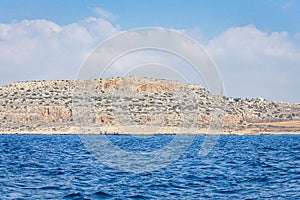 Small backwater surrounded by a stone cliff with azure water in Cyprus