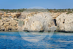 Small backwater surrounded by a stone cliff with azure water in Cyprus