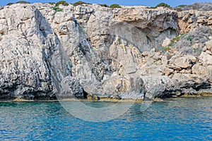 Small backwater surrounded by a stone cliff with azure water in Cyprus