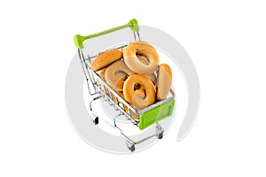 Small bagels in a metal shopping trolley isolated on white.