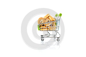 Small bagels in a metal shopping trolley isolated on white.