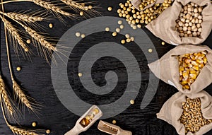 Small bags with various grains and cereals on wooden table, top view, copy space