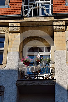 Small balcony with flowers in an old house in Europe