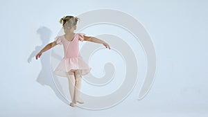 A small ballerina dances with enthusiasm. The girl is engaged in ballet