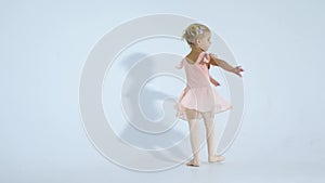 A small ballerina dances with enthusiasm. The girl is engaged in ballet