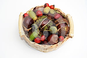 Small basket with horse chestnuts, acorns and rose hips