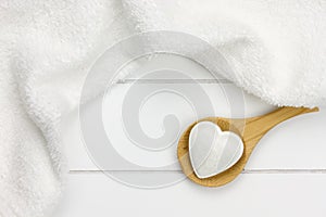 Small bath bomb in heart shape on wooden spoon photo