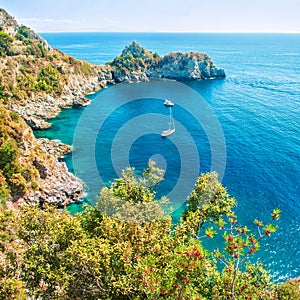 Small bay with boats in Aegean sea surrounded by rocks