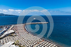 Small beach full of colorful sunbeds and umbrellas