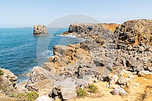 Small beach on the Islet of Papo in Peniche with a calm dark blue sea in Leiria, Portugal