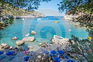 Small beach with tourists, umbrellas and sun chairs in Anthony Quinn bay Rhodes, Greece