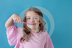 Small beautiful girl cleans teeth toothbrush Dentistry