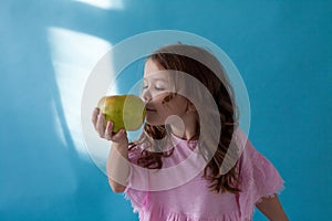Small beautiful girl eating Apple green teeth