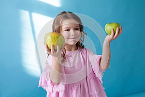 Small beautiful girl eating Apple green teeth