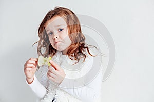 Small beautiful girl eating Apple green teeth